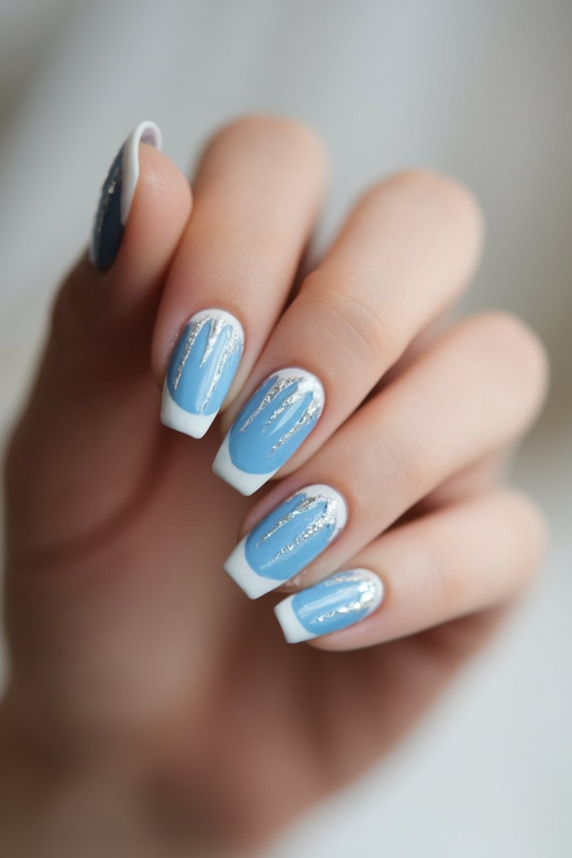Stylish blue and white manicure with silver accents on square-shaped nails. Fashionable nail art design close-up.